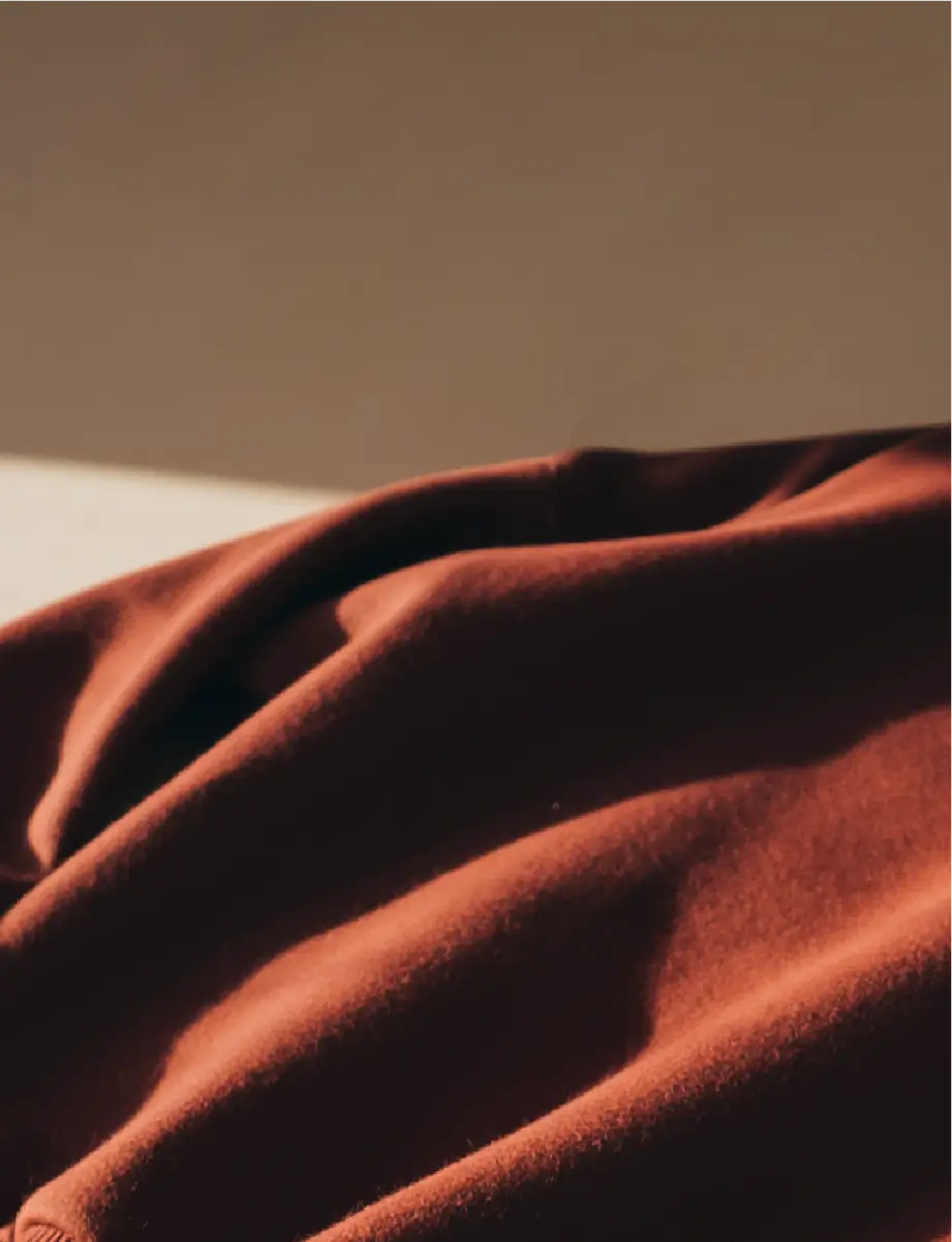 Blurred close-up of brown fabric texture resembling a sweatshirt